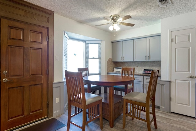 dining space with light hardwood / wood-style floors and ceiling fan