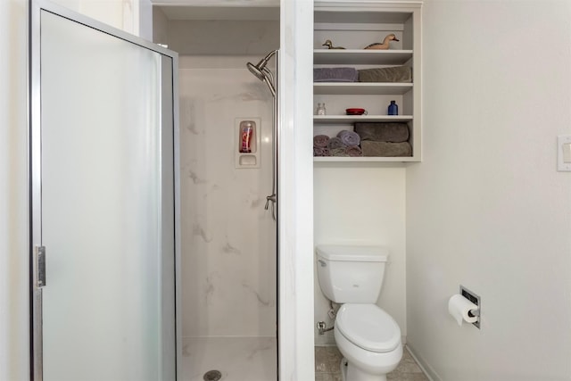 bathroom featuring toilet and a shower with door