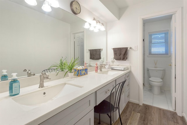 bathroom featuring hardwood / wood-style flooring, toilet, vanity, and a notable chandelier