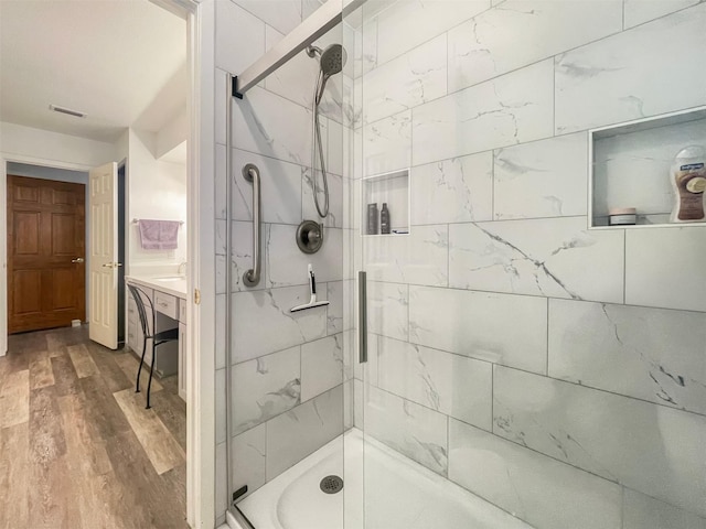 bathroom featuring hardwood / wood-style floors, vanity, and a shower with shower door