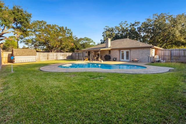 view of pool with a yard and french doors