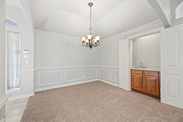 unfurnished dining area with lofted ceiling with beams, sink, light colored carpet, and a notable chandelier