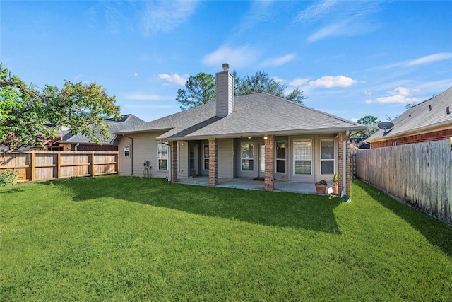 rear view of house featuring a yard and a patio area