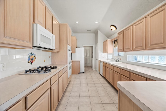 kitchen featuring sink, light brown cabinets, backsplash, white appliances, and light tile patterned floors