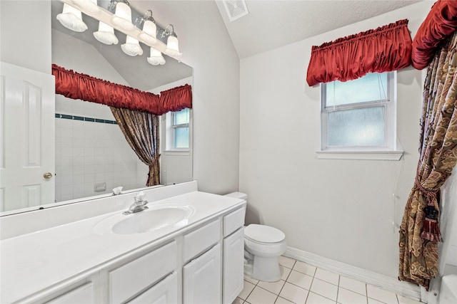 bathroom with a textured ceiling, vanity, vaulted ceiling, tile patterned flooring, and toilet