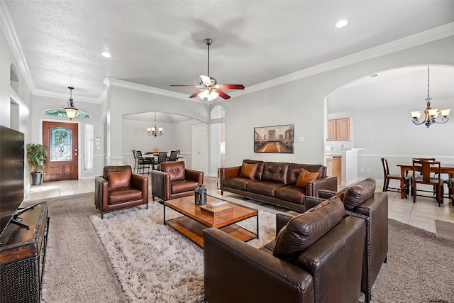 tiled living room featuring a textured ceiling, ceiling fan with notable chandelier, and ornamental molding