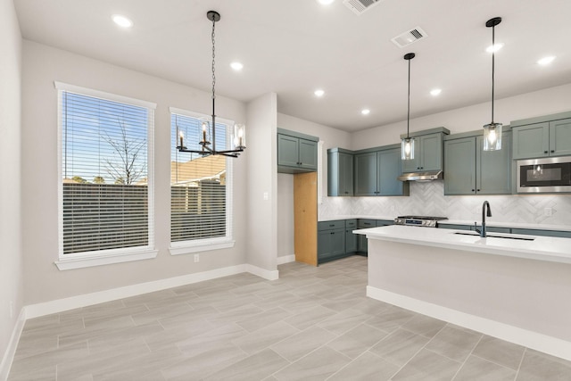 kitchen with pendant lighting, sink, decorative backsplash, and an inviting chandelier