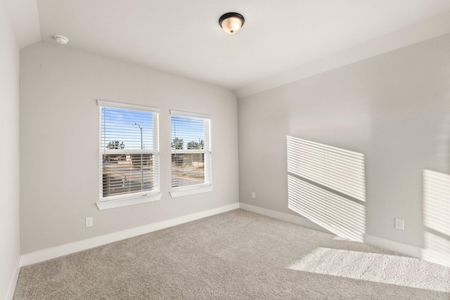 unfurnished room featuring vaulted ceiling and carpet