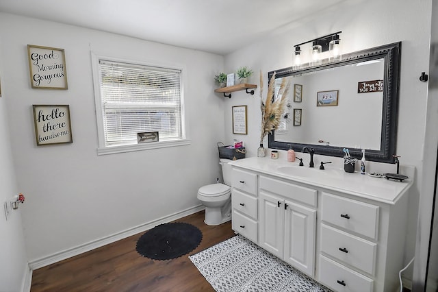 bathroom with hardwood / wood-style floors, vanity, and toilet