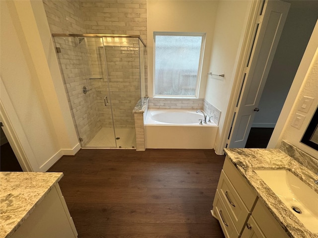 bathroom featuring plus walk in shower, hardwood / wood-style flooring, and vanity