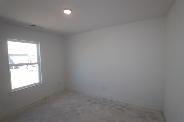 spare room featuring visible vents and unfinished concrete floors