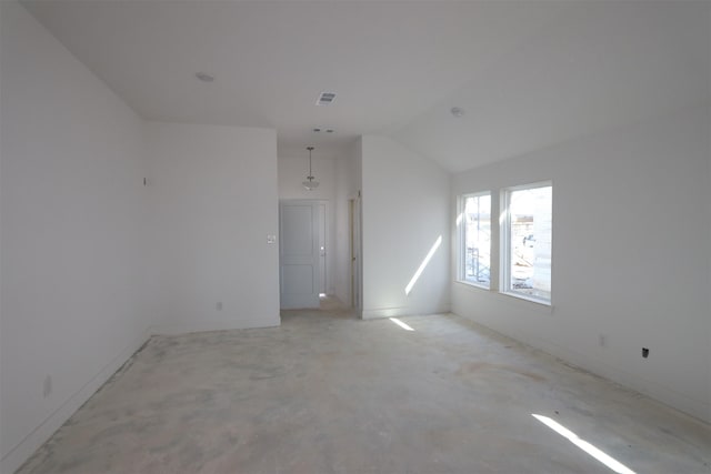 unfurnished room featuring lofted ceiling, unfinished concrete floors, and visible vents