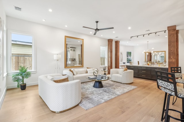 living room featuring ceiling fan, light hardwood / wood-style floors, and ornate columns