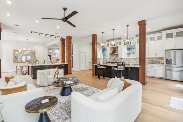 living room with decorative columns, ceiling fan, light hardwood / wood-style flooring, and track lighting