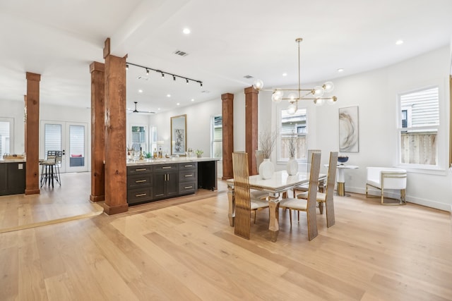 dining room with ceiling fan with notable chandelier and light wood-type flooring