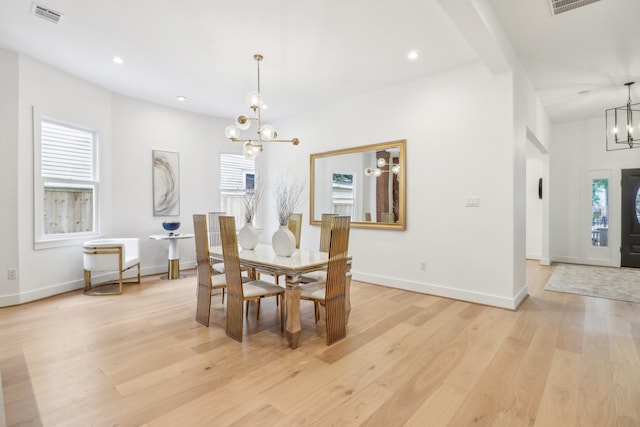 dining room with light hardwood / wood-style floors, beam ceiling, and a chandelier