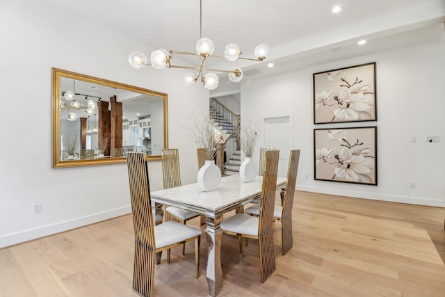 dining area featuring light hardwood / wood-style flooring and a chandelier