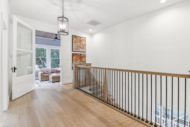 hall with a chandelier and light hardwood / wood-style flooring