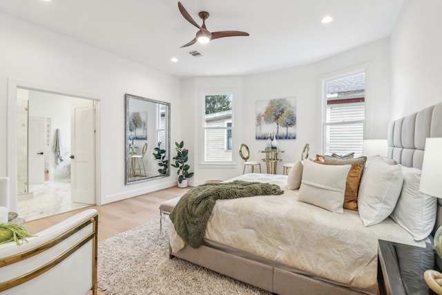 bedroom featuring ceiling fan, connected bathroom, and light hardwood / wood-style flooring