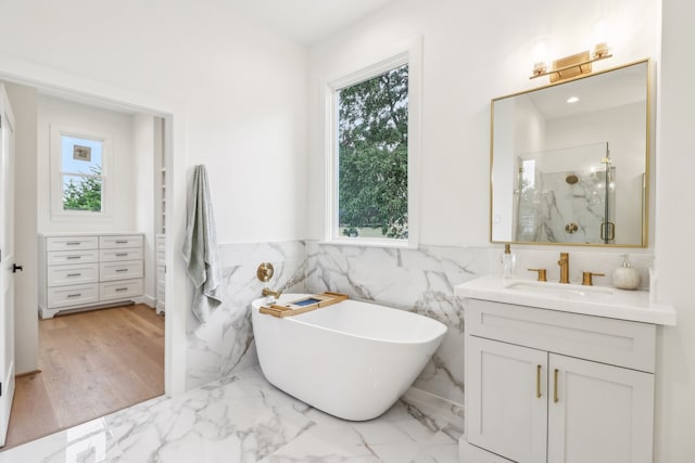 bathroom with hardwood / wood-style flooring, vanity, tile walls, and independent shower and bath