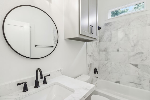 full bathroom with vanity, tiled shower / bath combo, and toilet