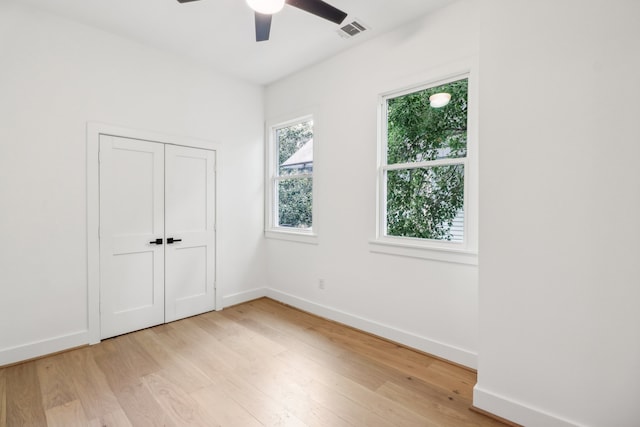 unfurnished bedroom with a closet, light hardwood / wood-style floors, and ceiling fan