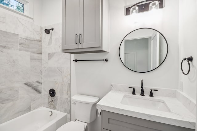 full bathroom featuring vanity, tiled shower / bath combo, and toilet