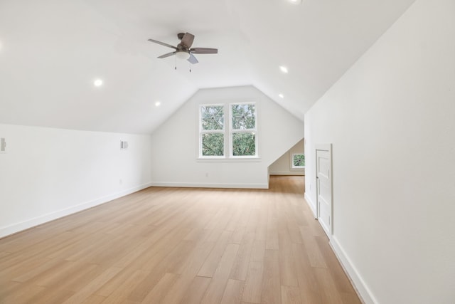 additional living space featuring ceiling fan, light wood-type flooring, and vaulted ceiling