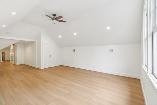 additional living space with ceiling fan, lofted ceiling, and light wood-type flooring