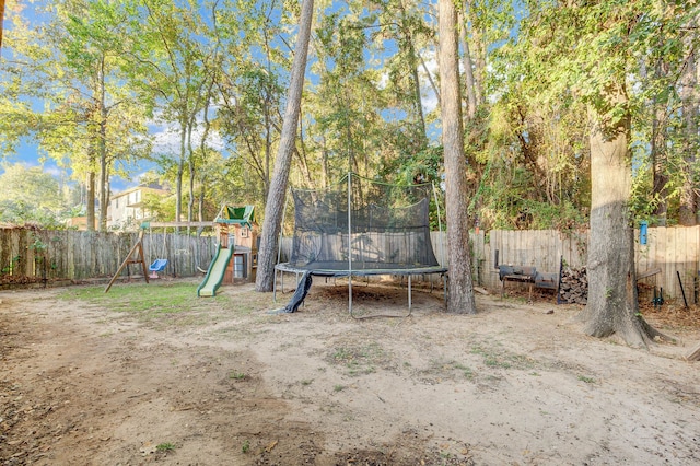 view of yard with a playground and a trampoline