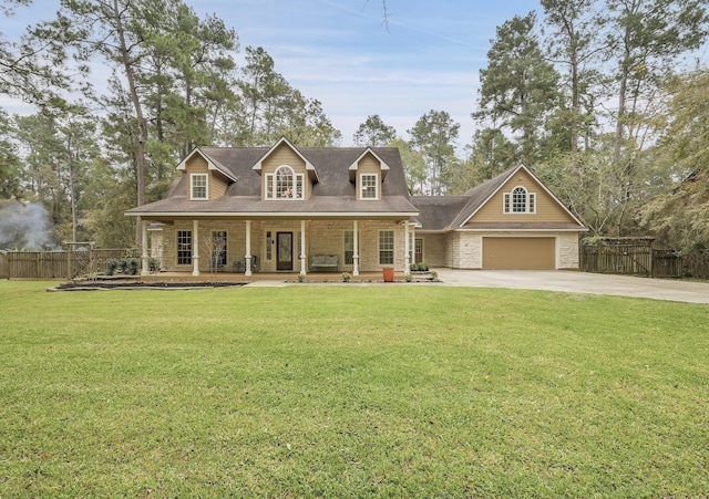 view of front of property featuring driveway, stone siding, a porch, fence, and a front lawn