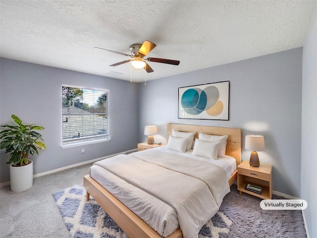 bedroom with carpet flooring, ceiling fan, and a textured ceiling