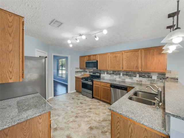 kitchen with pendant lighting, sink, kitchen peninsula, and stainless steel appliances