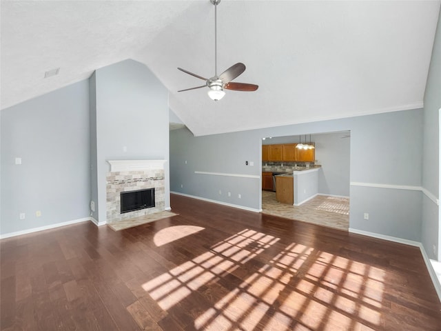 unfurnished living room with a stone fireplace, ceiling fan, wood-type flooring, and vaulted ceiling