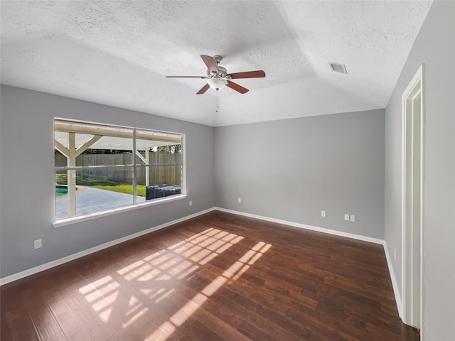 empty room featuring ceiling fan, dark hardwood / wood-style floors, a textured ceiling, and vaulted ceiling