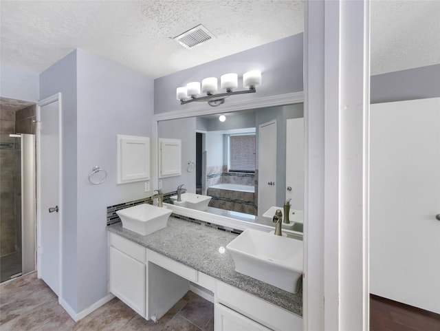 bathroom with vanity, separate shower and tub, and a textured ceiling