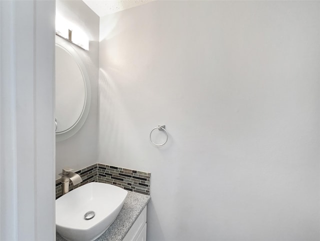 bathroom with tasteful backsplash and vanity