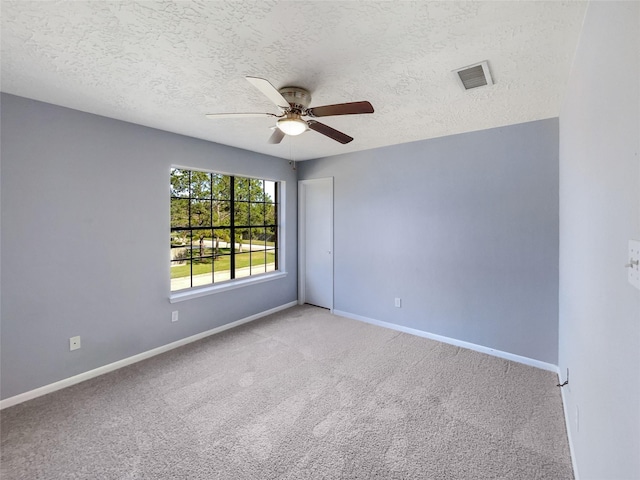 spare room featuring light carpet, a textured ceiling, and ceiling fan