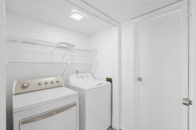 washroom featuring separate washer and dryer and a textured ceiling