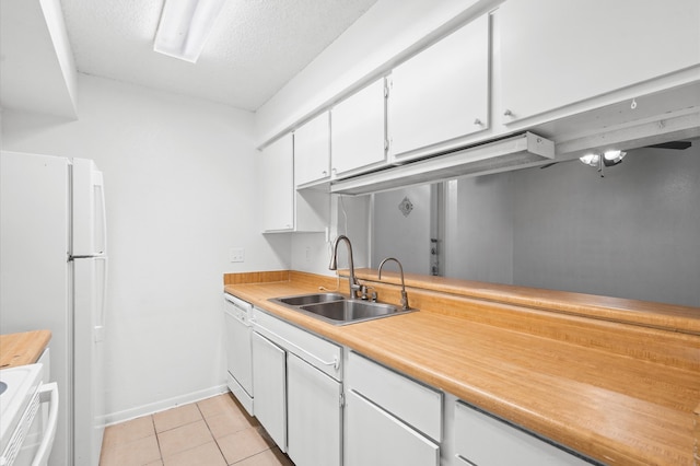 kitchen with sink, light tile patterned flooring, a textured ceiling, white appliances, and white cabinets