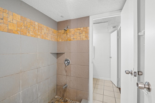 bathroom with tiled shower, a textured ceiling, and tile patterned flooring