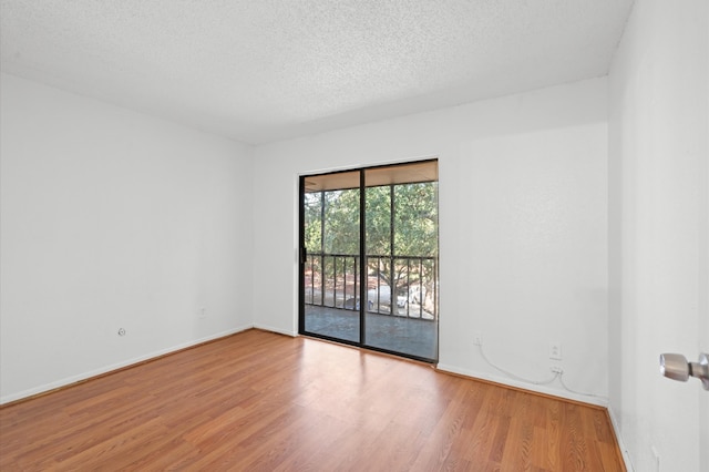 unfurnished room with wood-type flooring and a textured ceiling