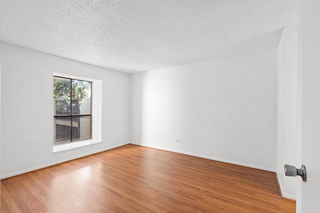 spare room with hardwood / wood-style floors and a textured ceiling