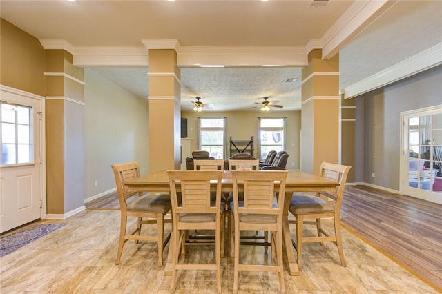 dining area with ornate columns, crown molding, ceiling fan, and light hardwood / wood-style floors