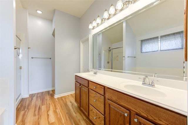 bathroom featuring hardwood / wood-style floors, vanity, and a shower with door