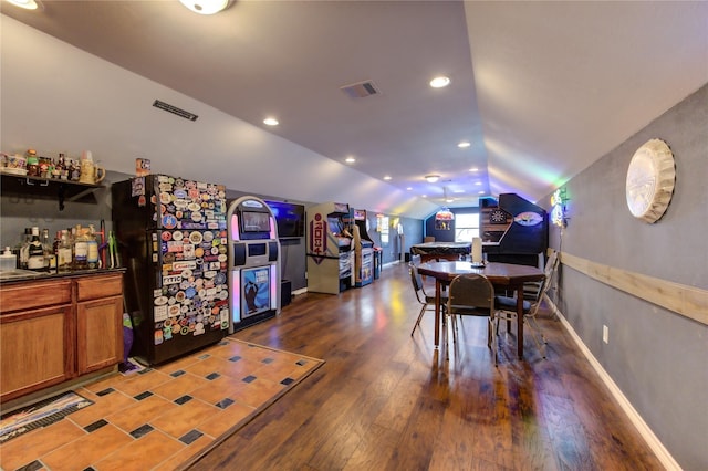 dining space with dark hardwood / wood-style flooring and vaulted ceiling