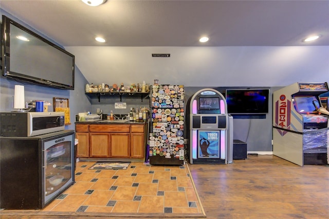 kitchen with light hardwood / wood-style floors, sink, wine cooler, and vaulted ceiling