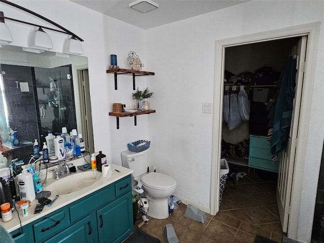 bathroom featuring toilet, vanity, tile patterned floors, and a shower with shower door