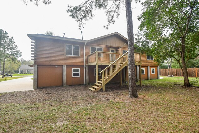 rear view of house with a lawn and a wooden deck