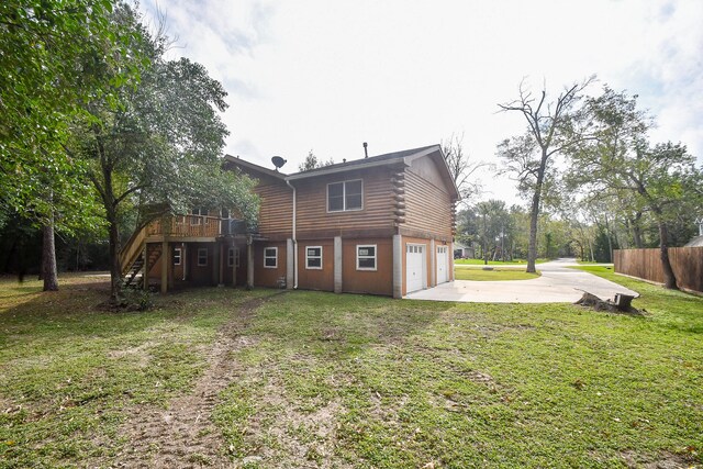 back of house featuring a yard, a garage, and a deck